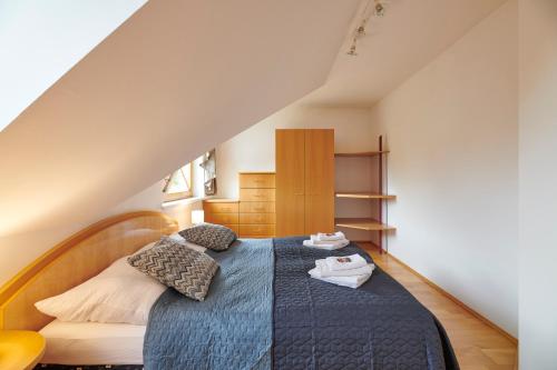um quarto com uma cama azul num sótão em DAS BURGENNEST, Bademantelgang zur Therme Lutzmannsburg, Garten, Parkplatz, Verpflegung auf Anfrage em Lutzmannsburg
