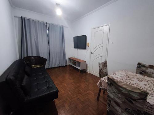 a living room with a couch and a table and a door at Apto/garagem coberta/900m-Centro in Registro