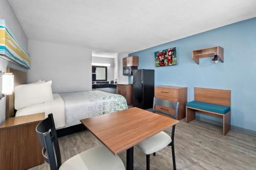 a small hotel room with a bed and a table at HomeTowne Studios by Red Roof San Antonio E - Frost Bank Center in San Antonio
