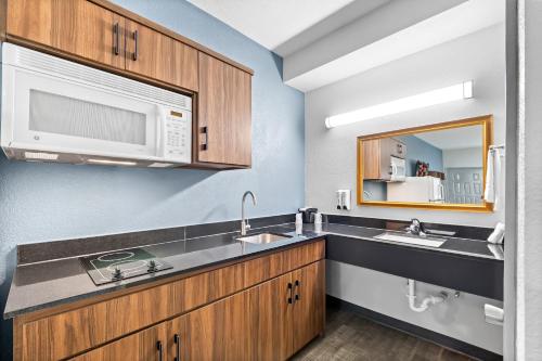 eine Küche mit zwei Waschbecken und einer Mikrowelle in der Unterkunft HomeTowne Studios by Red Roof San Antonio E - Frost Bank Center in San Antonio