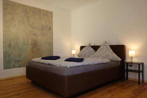 a bedroom with a bed with two lamps on it at Gemütliches Schmuckstück mit zwei Schlafzimmern in Mügeln