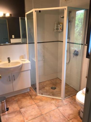 a bathroom with a shower and a sink and a toilet at Harbour views in Athenree