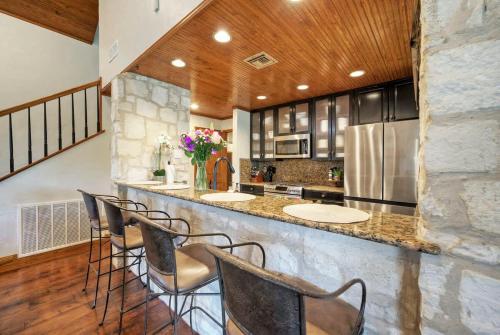 a kitchen with a bar with chairs and a counter top at Waterfront Sleeps 16 Perfect for Family & Wurstfest in McQueeney