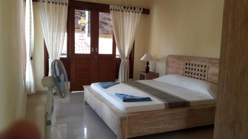Schlafzimmer mit einem Bett und einem Fenster in der Unterkunft Three Ayu Family House in Ubud