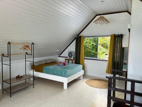 a bedroom with a bed and a window at Ave Surfing House in Mahina