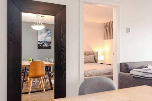 uma sala de estar com uma mesa e um quarto em Whistler Village Retreat, Private Hot Tub & Sauna em Whistler