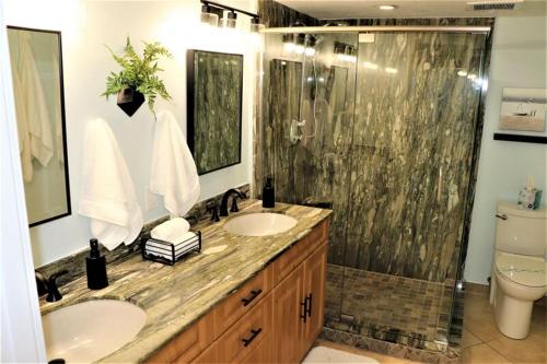 シエスタ・キーにあるGulf and Bay Club- M100のバスルーム(洗面台2台、シャワー、トイレ付)