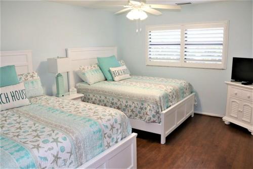 シエスタ・キーにあるGulf and Bay Club- M100の白いベッドルーム(ベッド2台、テレビ付)