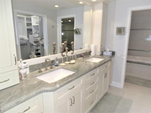 a bathroom with two sinks and a large mirror at Gulf and Bay Club- F401 in Siesta Key
