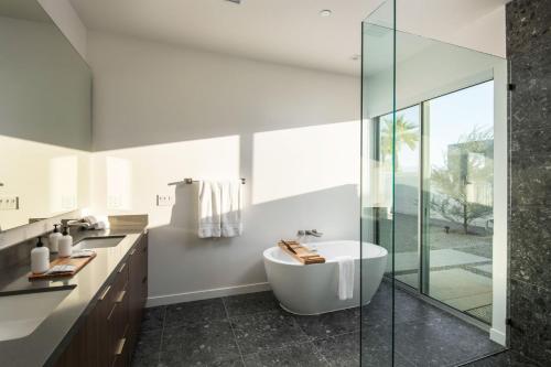 a bathroom with a tub and a glass shower at Neon @ Elemento49 Pool Spa Sleeps 16 in Desert Groves Mobile Home Park