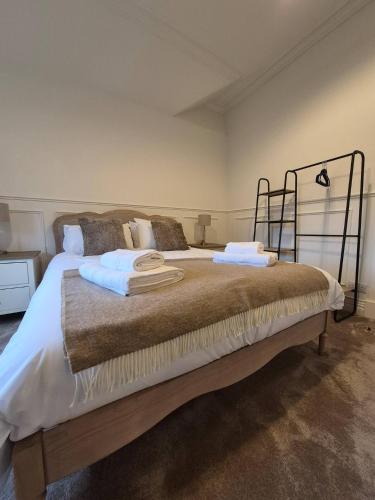 een slaapkamer met een bed met twee handdoeken erop bij Kirkgate 2 bed - Coorie Doon Stays in Irvine