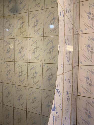 ジンジャにあるLa Jinjaの白いタイル張りの壁と鏡が備わるバスルーム