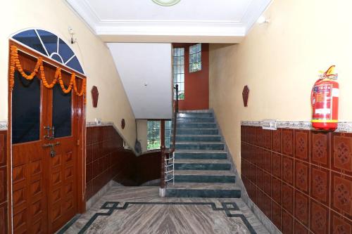 un escalier dans un bâtiment avec un escalier menant à une porte dans l'établissement Hotel O Sonora Hotel, à Dhanbād
