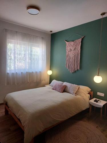 a bedroom with a large bed with a green wall at בדרך לנחל הבניאס in Sde Nehemia
