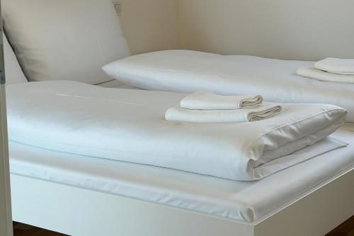 two beds with white sheets on top of them at Danube Suites in Vienna