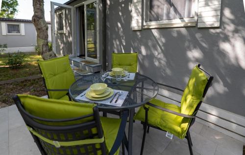a glass table and chairs on a patio at 2 Bedroom Cozy Stacaravan In Obrovac in Obrovac