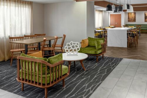 a lobby with chairs and a table and a dining room at Fairfield Inn & Suites Saginaw in Saginaw