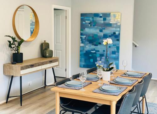 - une table à manger avec des chaises et un miroir dans l'établissement Modern townhouse, walking distance to town centre, à Yarra Glen