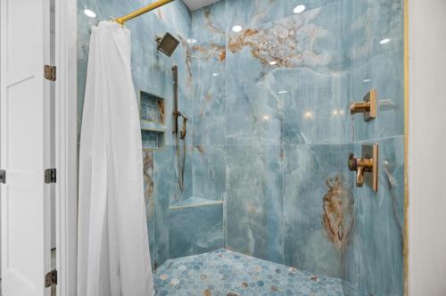 a bathroom with a shower with a blue wall at Lemon Bay Luxe – Dock, Beach & Manasota Vibes in Punta Gorda Beach