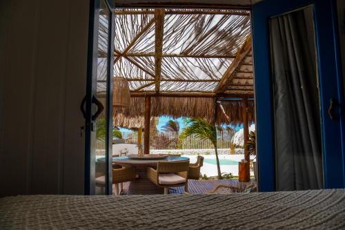 um quarto com uma cama e vista para um pátio em Tulum House Ilha do guajiru, Itarema em Itarema