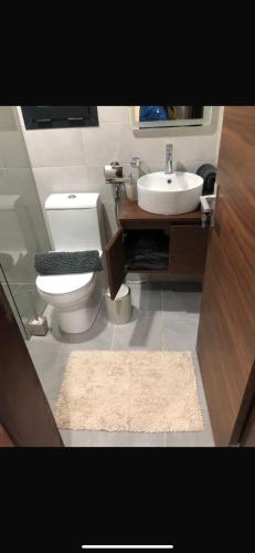 a bathroom with a white toilet and a sink at Aquaview in Bijilo