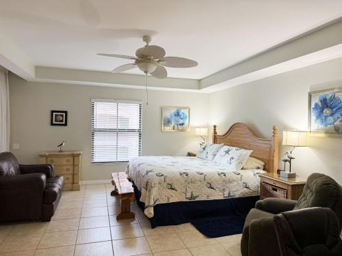 a bedroom with a bed and a ceiling fan at Stylish Gulf Condo - Walk to Beach, Pool & Dining in Punta Gorda Beach