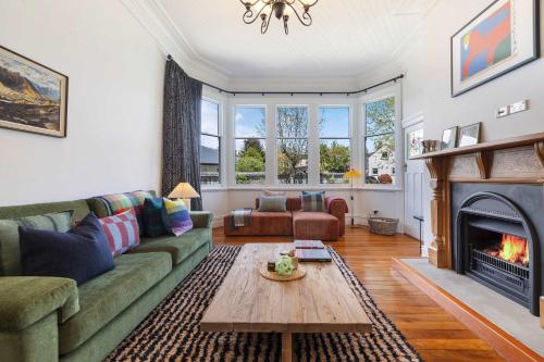 a living room with a couch and a fireplace at The 1909 Gables Villa in Arrowtown