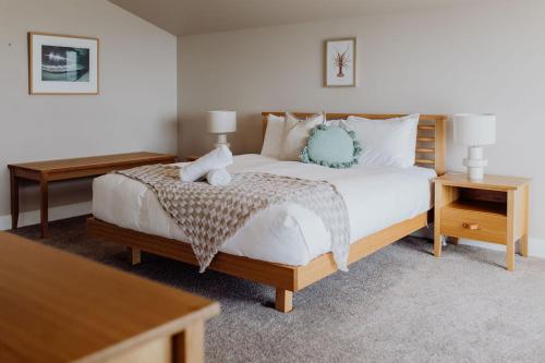 a bedroom with a large white bed with two tables at Haven on James in Bicheno