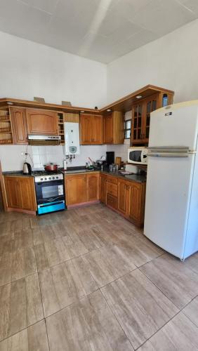 eine Küche mit weißem Kühlschrank und Holzschränken in der Unterkunft El Descanso Placentero in Cordoba