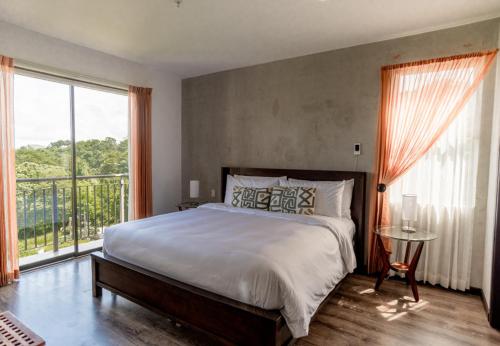 a bedroom with a large bed and a large window at A10- Roble Sabana 201 in Playa Conchal