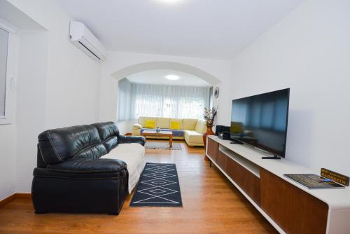 a living room with a couch and a television at Casa do Cantinho do Muro in São Vicente
