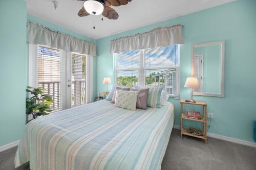 Un dormitorio con una cama con paredes y ventanas azules. en Gulf Sands – 3BR Steps to Pool & Private Beach, en Punta Gorda Beach