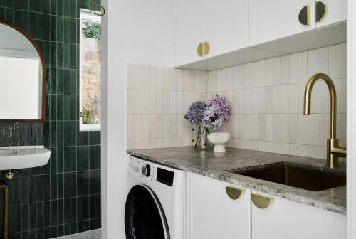 a kitchen with a sink and a washing machine at Bendigo Signature Accommodation Wattle Street in Bendigo