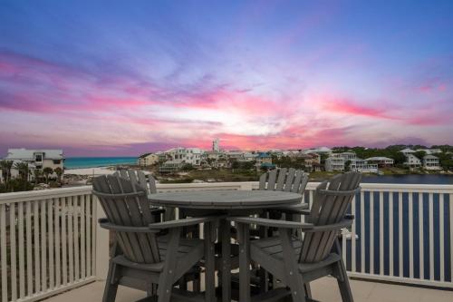une table et des chaises sur un balcon avec vue sur l'océan dans l'établissement Dock N Dune by 30A Escapes, à Seagrove Beach