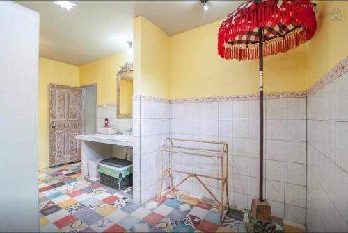 a bathroom with a tile floor and a red umbrella at Seminyak Villa Hibiscus in Seminyak