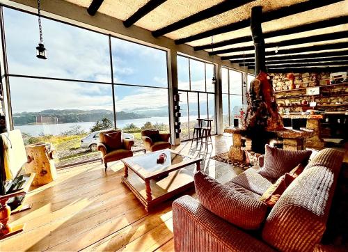 a living room with couches and a table and large windows at Casa Grande Sidarta 3 alcobas - Casita pequena 2 alcobas in Chocontá