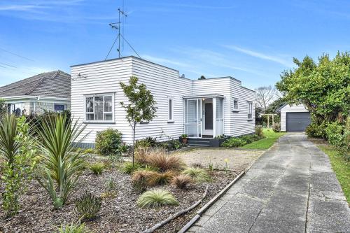 ein weißes Haus mit einer Auffahrt davor in der Unterkunft Boxed Bliss on Fox in Hamilton