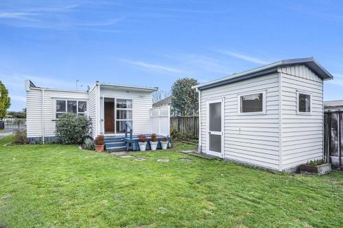 een klein wit tiny house in een yard bij Boxed Bliss on Fox in Hamilton