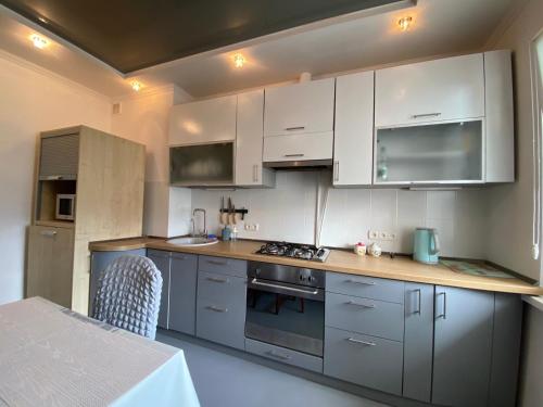 a kitchen with white cabinets and a stove top oven at 3-badroom flat near the sea with 12 places to sleep in Sychavka