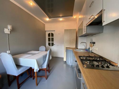 a kitchen with a table and a stove top oven at 3-badroom flat near the sea with 12 places to sleep in Sychavka