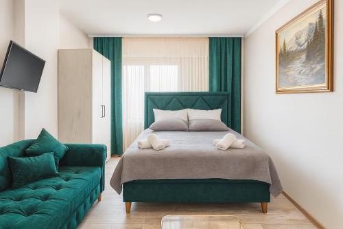 a bedroom with a green bed and a green couch at Vila Petunija in Sjenica