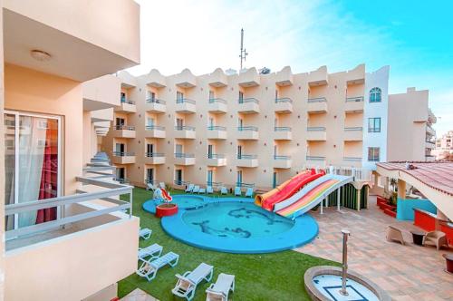 an apartment patio with a pool and a hotel at Dexon Roma Down Town Hotel in Hurghada