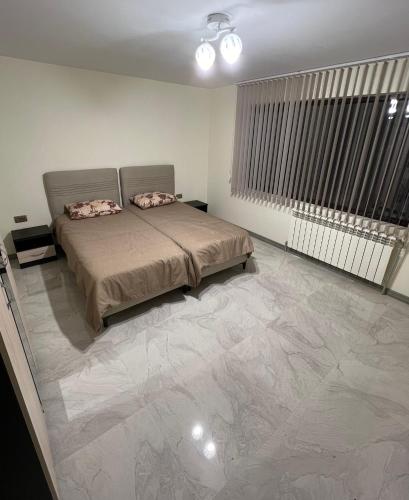 a bedroom with a bed and a large marble floor at Квартира in Kozloduy