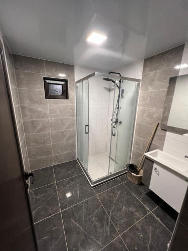 ein Badezimmer mit Dusche und Waschbecken in der Unterkunft Квартира in Kozloduy