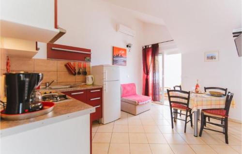 a kitchen and dining room with a table and chairs at Lovely Apartment In Omis With Wifi in Tice