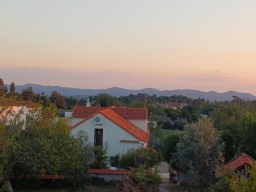 a white house with an orange roof with mountains in the background at Quinta Revira Volta in Nesperal
