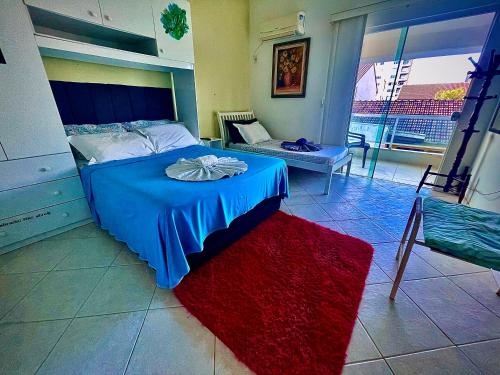 a bedroom with a blue bed and a red rug at A Pérola do Gravatá in Navegantes