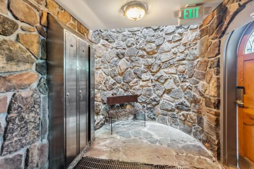 un mur de pierre dans un couloir avec une porte et une chaise dans l'établissement Chateaux DuMont 4 Bedroom Homes by Summit County Mountain Retreats, à Keystone