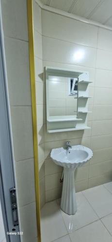 łazienka z białą umywalką i lustrem w obiekcie Iline Residence Large studio w mieście Dżidżili