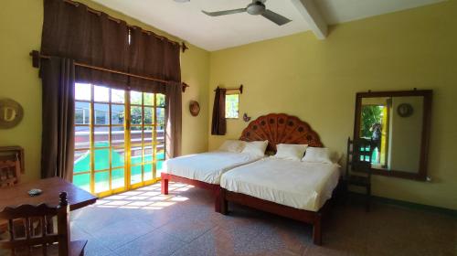 a bedroom with a bed and a large window at Jungle Palace hostal santaella in Puerto Escondido